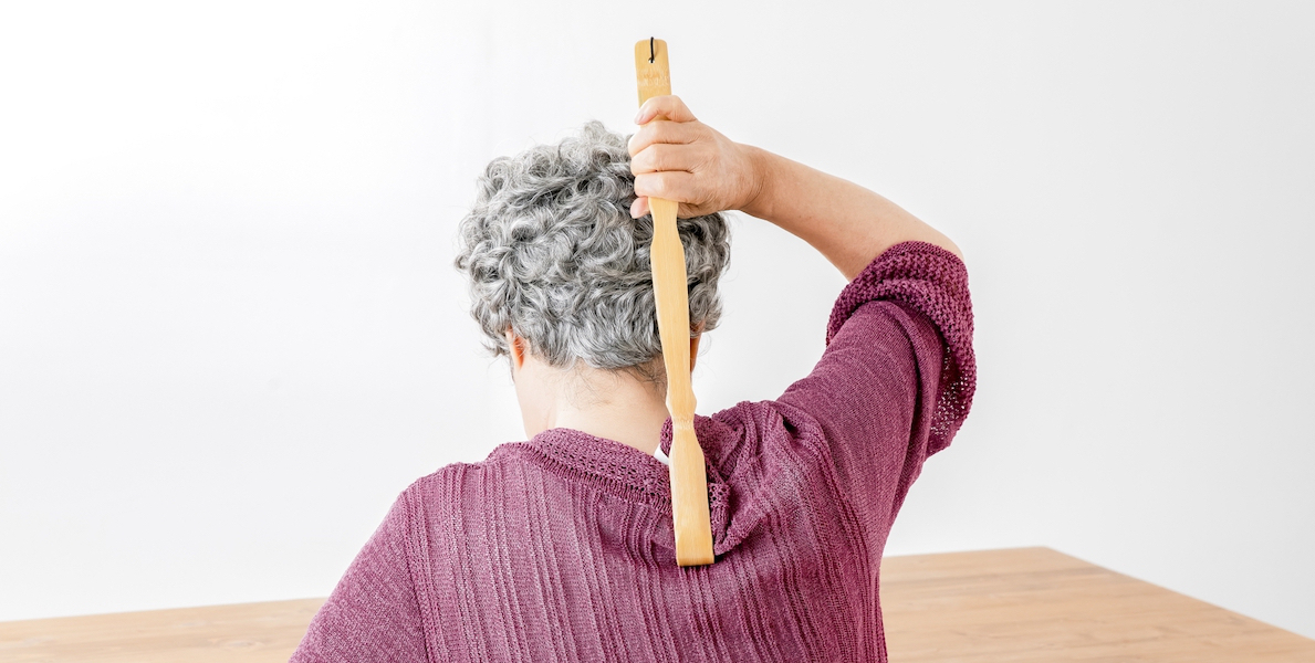 Elderly woman using backscratchers