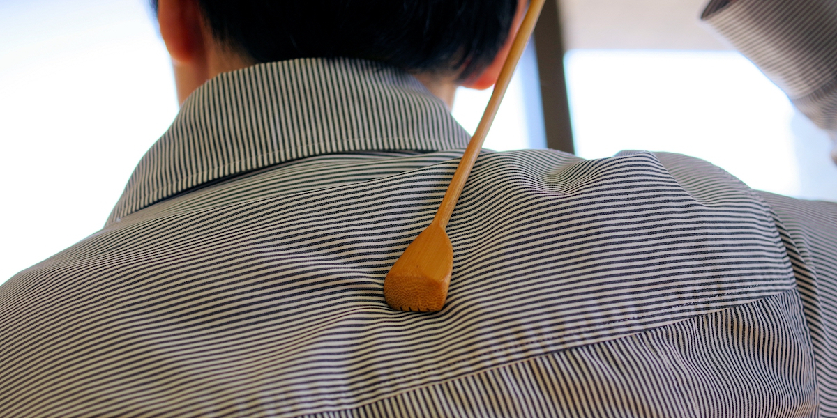 Elderly man using backscratchers