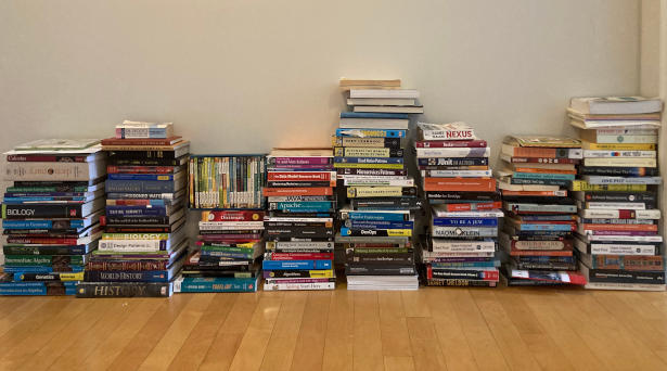 Books, most of them are about programming,  put on a wooden floor in eight piles.