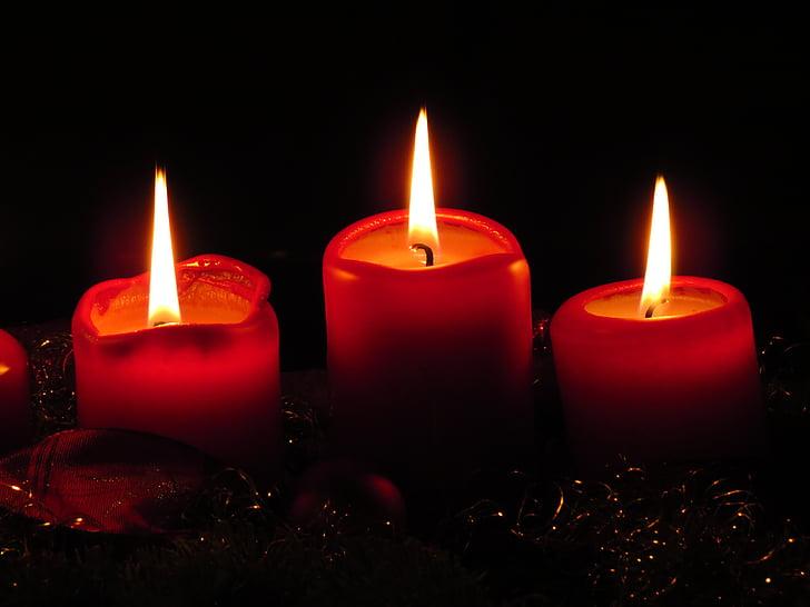 Three red candles lit in the dark